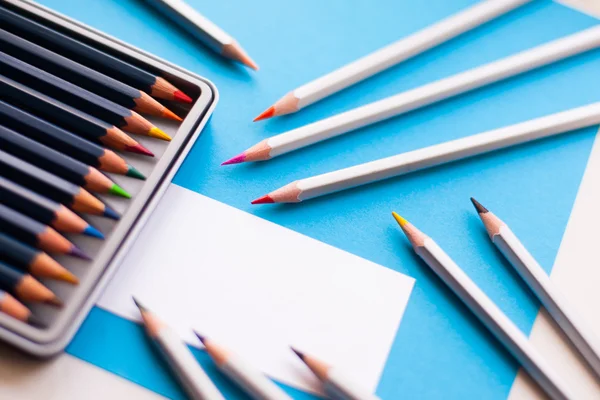Színes ceruzák, világos kék háttér és egy üres — Stock Fotó