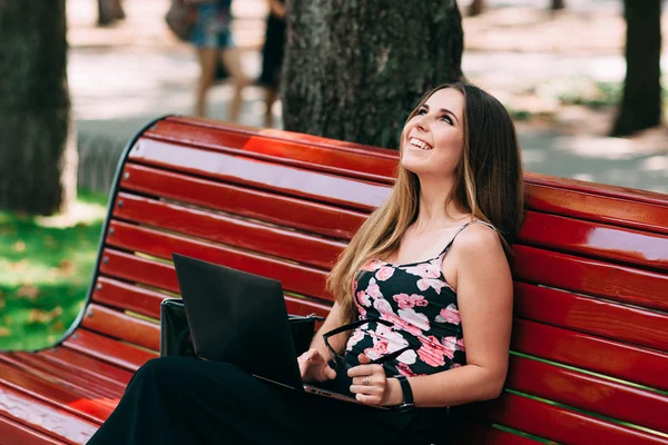 Szczęśliwy uczeń z laptopa w parku miejskim — Zdjęcie stockowe