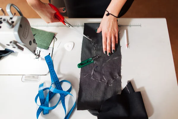 Dressmaker cuts dress detail on the sketch — Stock Photo, Image