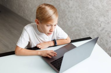 Bilgisayarı olan bir çocuk karantinada online eğitim görüyor.