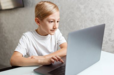 Bilgisayarı olan bir çocuk karantinada online eğitim görüyor.