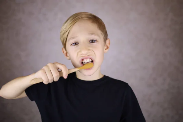 Oğlan Dişlerini Fırçalıyor Elinde Ahşaptan Yapılmış Eko Fırça Tutuyor — Stok fotoğraf