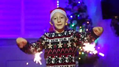 Ellerinde maytap olan bir çocuk yeni yıl arkaplanında dans ediyor.