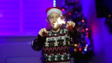 Ellerinde maytap olan bir çocuk yeni yıl arkaplanında dans ediyor.