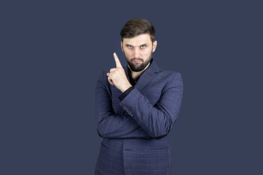 Bir iş adamı. Sakallı ve mavi takım elbiseli bir adam. İşaret parmağıyla yönü gösteriyor.