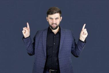 Bir iş adamı sakallı ve mavi takım elbiseli bir adam iki eliyle yolu gösteriyor.