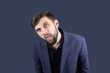 Mavi elbiseli işadamı ağzını açtı ve dilini dışarı çıkardı.