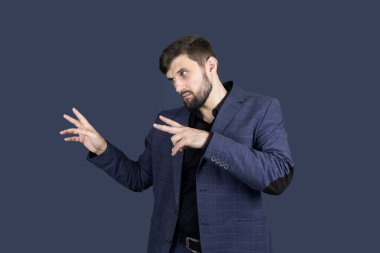 Mavi takım elbiseli şık bir adam iki eliyle yönünü gösterir.