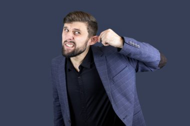 Mavi takım elbiseli bir adam kulağını çekiyor.