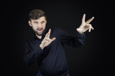 Siyah gömlekli bir adam elleriyle hareket eder.