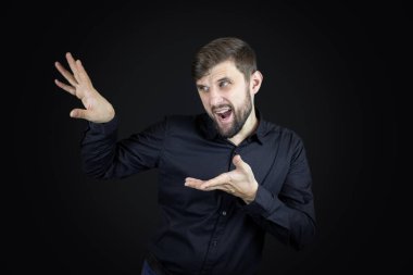 Siyah gömlekli bir adam elleriyle hareket eder.