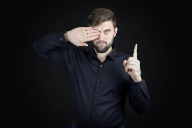 Siyah gömlekli bir adam elleriyle hareket eder.