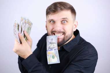 İşadamı faturaları elinde ve dişlerinde tutuyor.