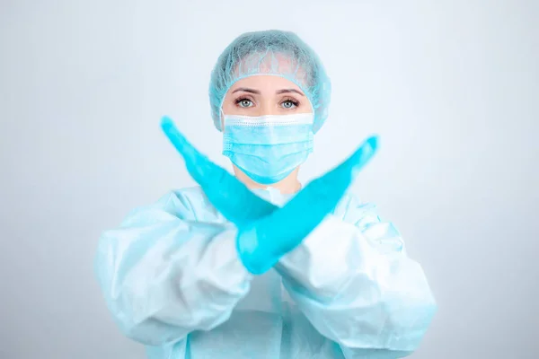 医療用のガウンとマスクと防護手袋を着た女性看護師が腕を前にして直立し — ストック写真