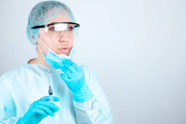 透明ガラスで医療用のガウン マスク 保護手袋の看護師は 彼女の顔からマスクを削除します — ストック写真