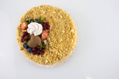 Beyaz masanın üstünde böğürtlenli kek.