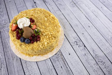 Böğürtlenlerle süslenmiş beyaz ahşap masaya yakın plan bir pasta.