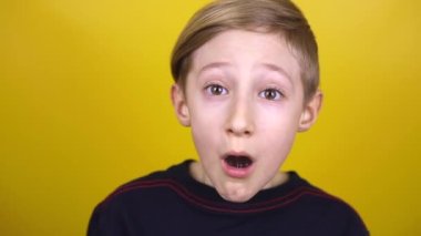 Çocuk ağzını açar ve esner. Çocuk sarı arka planda çeşitli duygular sergiliyor..