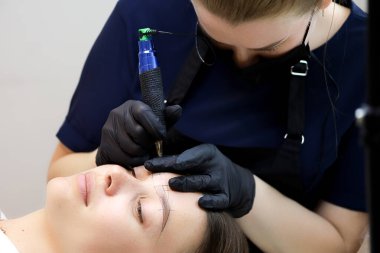 Kalıcı makyöz kaşlarının dövmesini daha önce çizilen izlere göre yapar.