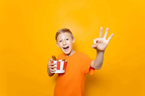 Pojke Orange Shirt Håller Pappershink Med Kycklingvingar Framför Sig Och — Stockfoto