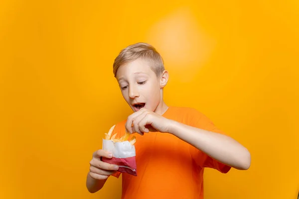 Pojke Orange Shirt Håller Påse Friterad Potatis Framför Sig Och — Stockfoto