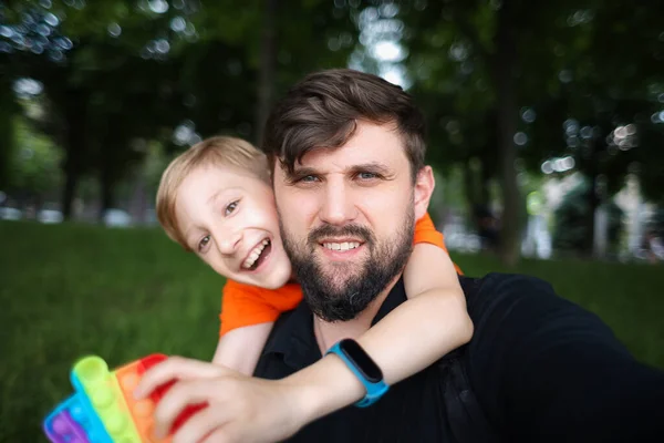 Vader Kijkt Naar Camera Neemt Een Selfie Het Kind Knuffelt — Stockfoto