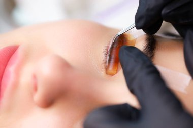 Silia 'nın kaplamasının ustasının ellerine yakın çekim yap silindiri yapıştır ve siliyi düzleştir.