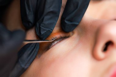 Ustanın elleri... Özel cımbızla silindire yapıştırılmış kirpiği düzelt.