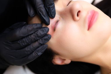 Kireçlenme ustaları müşterilerin üzerine eğildi ve tüm siliyi görmek için göz kapaklarını uzattı.