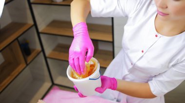 Şekerleme uzmanımız elindeki kovadan şeker macunu topluyor.