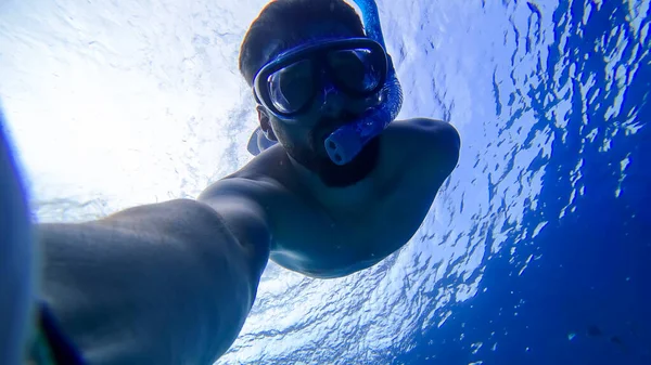 男はマスクと呼吸管で紅海の底に潜るシュノーケリングに従事しています — ストック写真