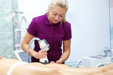 Usta, vakumlu masaj cihazıyla manken için anti-selülit masajı yapıyor.