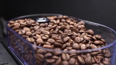 Kahve yapan bir kahve makinesi için kahve çekirdeğini bir kabın içinde dolduruyorum.