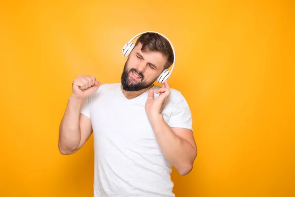 bearded man in musical headphones closed his eyes and listens to music.