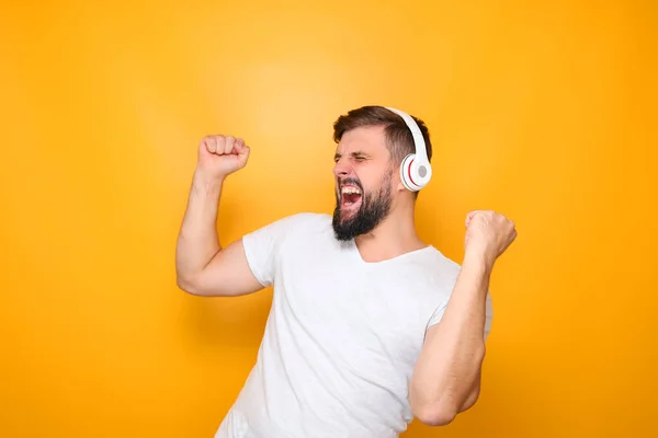 Mann Med Hvite Hodetelefoner Hører Musikk Synger Høyt Løfter Hendene – stockfoto