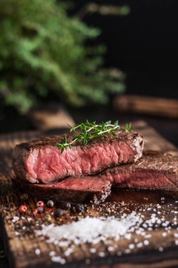 steak cut on a wooden board on a dark background