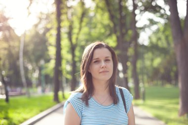 Arka tarafından ışık yaktı parkta genç bir kadın portresi