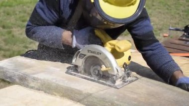 Stanley 1700 Watt 'lık dairesel testereyle odun kesen bir işçi.