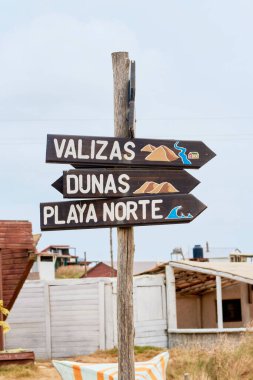 Cabo Polonio, Uruguay 'da elle boyanmış ahşap tabela Valizas' a, kum tepelerine ve kuzey sahillerine giden yolu gösteriyor..