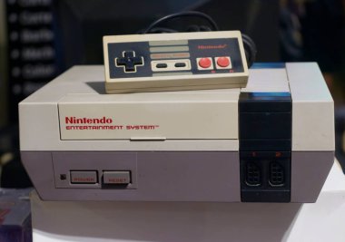 Orijinal denetleyicisiyle birlikte Nintendo Eğlence Sistemi konsolu, video oyunu tarihinin ikonik bir parçasını ve 80 'lerin teknoloji kültürünü gösteriyor.