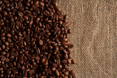 Kahve çekirdekleri çuvala saçılmış.