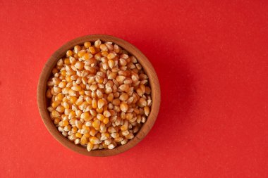 Tarla Mısırı ahşap kasede kırmızı arka planda patlamış mısır