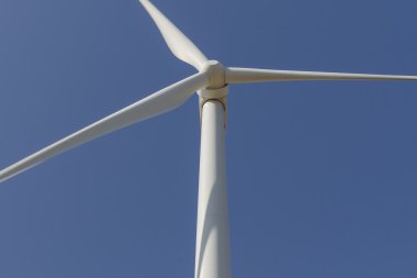 Mavi gökyüzü üzerinde alternatif enerji üreten rüzgar türbini