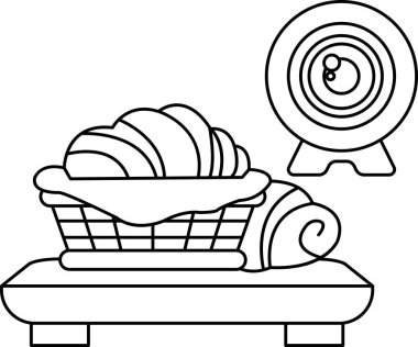 Masada bir sepet yiyecek bir kameranın yanında. Sepet çeşitli hamur işleri ve ekmekler içeriyor ve kamera onun üzerinde yer alıyor. Hoşgörü ve keyif kavramı