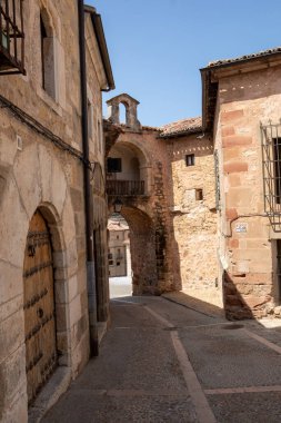 Eski taş binalar, ortaçağ kasabasında dar bir cadde çiziyor. Güneş ışığı yıpranmış duvarlara sıcak bir ton yayar ve dingin bir atmosfer yaratır. Her köşe başında tarihi bir an bekliyor..