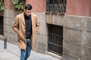 Şık bir adam dar bir kaldırım taşı caddesinde geziyor. Deve renginde bir ceket ve siyah bir yelek giyiyor. Güz havasının tadını çıkarırken düşüncelere dalmış..