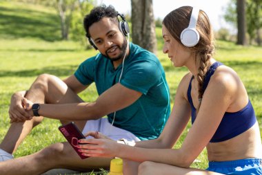 İki arkadaş yemyeşil bir parkta çimde oturup kulaklıkla müzik dinliyorlar. Sıcak güneş, akıllı bir telefondan birbirine bağlanıp kaygısız bir öğleden sonranın tadını çıkarırken parlıyor..
