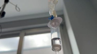 Bel artrodesisinden sonra IV terapisiyle hidratasyonun önemini gözlemliyorum. Kurulum, iyileşme ve refahı destekleyen sakin bir hastane ortamını vurguluyor.