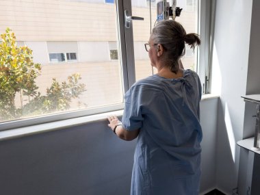 Bir hasta pencerenin kenarında durup dışarı bakar ve bel omurilik füzyon ameliyatından sonraki iyileşme yolculuğunu yansıtır. Oda, umudu sembolize eden doğal ışıkla dolu..