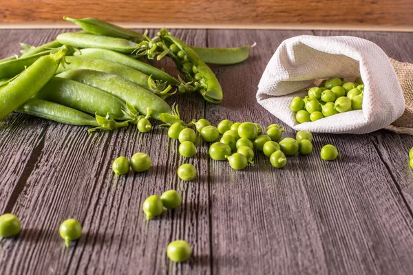 Guisantes en una mesa de madera —  Fotos de Stock